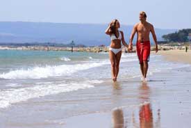 Photo of couple walking along Sandbanks beach in Poole, Dorset